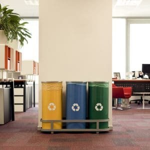 Yellow, blue, and green recycle bins set up in an office 