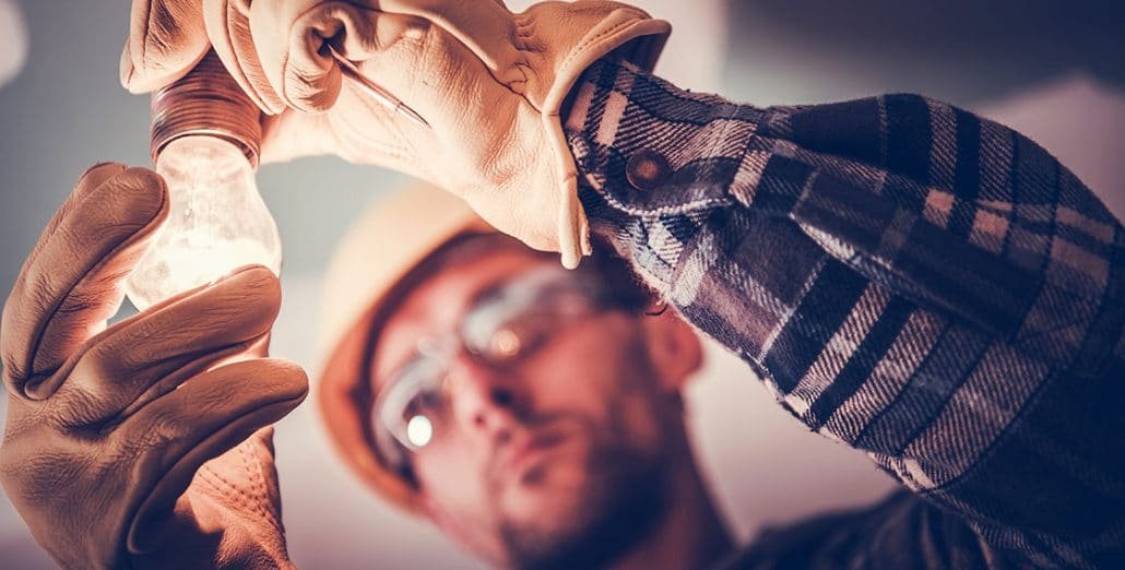 Electrician fixing light bulb