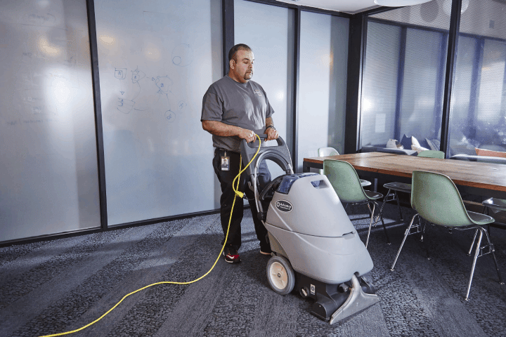 A janitor cleaning the carpet at a commercial site