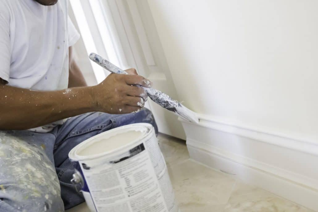 A man painting the walls white
